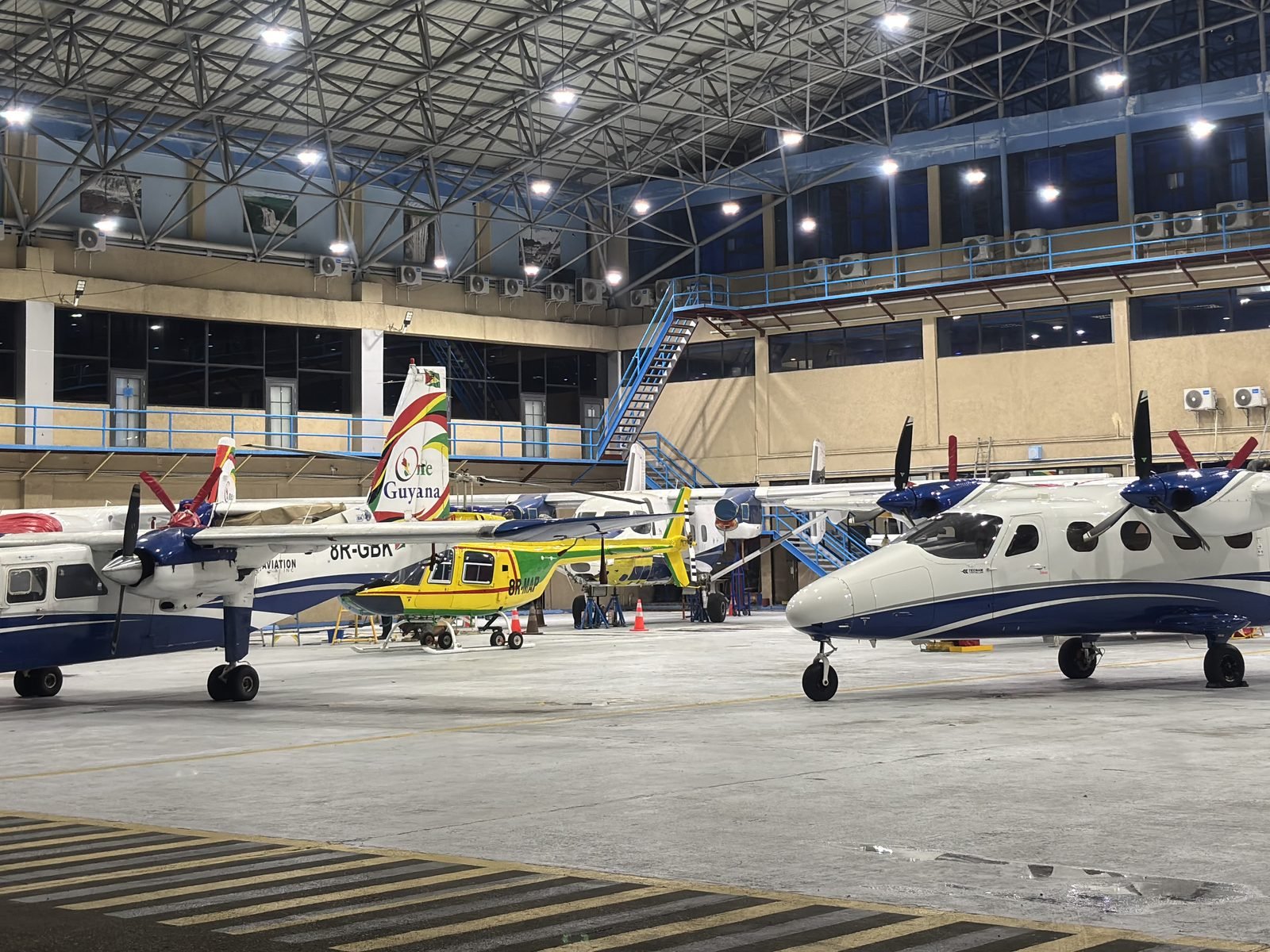 Jags Aviation fleet in the hangar at night: Britten-Norman Islander, Tecnam P2012 and helicopter